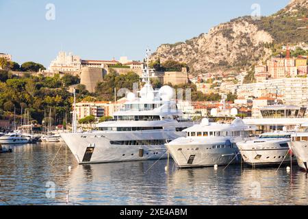 Monte Carlo, Monaco - Port Hercule with luxury yachts,  boats, and scenery skyline Stock Photo