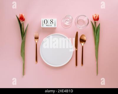 Beautiful table setting with pink tulip flower on light blue background ...