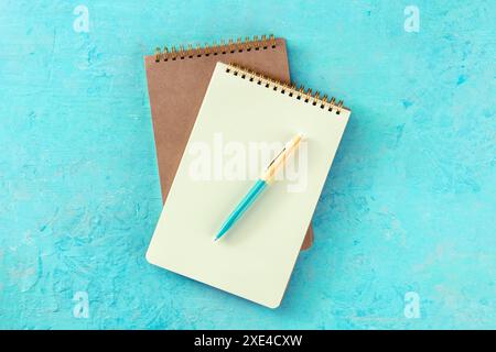 Notebook mockup with a pen, overhead flat lay shot on blue Stock Photo