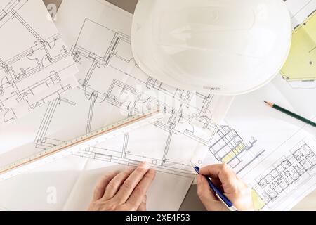 Top view of an architect hands working on Architecture plans on desk Stock Photo