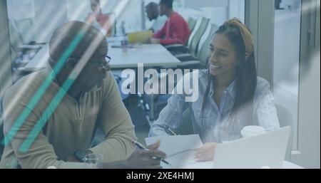 Image of multiple graphs and globe over multiracial colleagues analyzing documents on desk Stock Photo