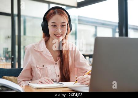Young collage student using computer and mobile device studying online. Stock Photo