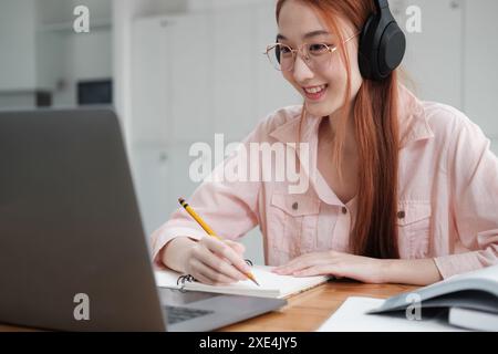 Young collage student using computer and mobile device studying online. Stock Photo