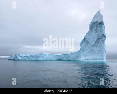 A huge high breakaway glacier drifts in the southern ocean off the coast of Antarctica at sunset, the Antarctic Peninsula, the S Stock Photo