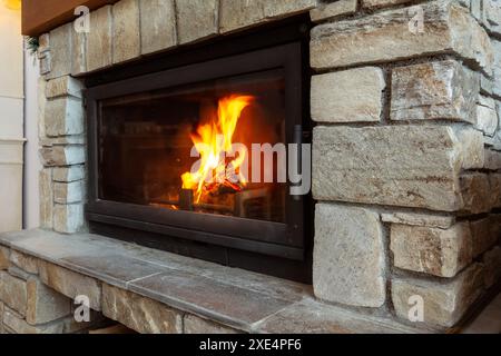 Stone Fireplace with burning fire, Cozy Winter Stock Photo