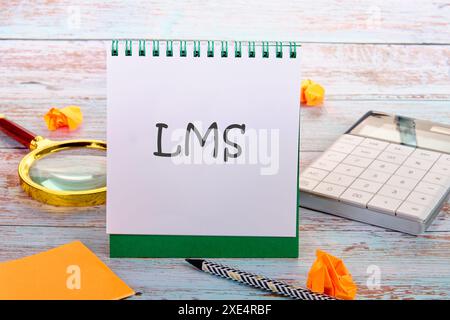 LMS- Learning Management System written in an upright notebook in a composition with office supplies Stock Photo