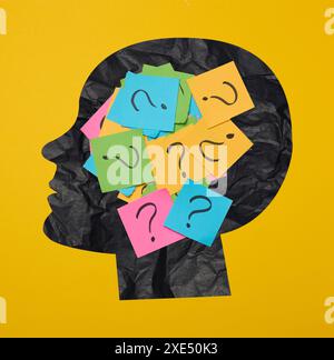 Silhouette of a person's head with a sticker inside, featuring drawn question marks, symbolizing the concept of searching for tr Stock Photo