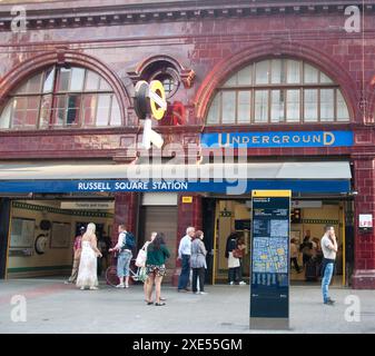 Traditional style underground station with tiles, although modern interior, people waiting and walking near entrance, map and litter bins.Designed by Stock Photo