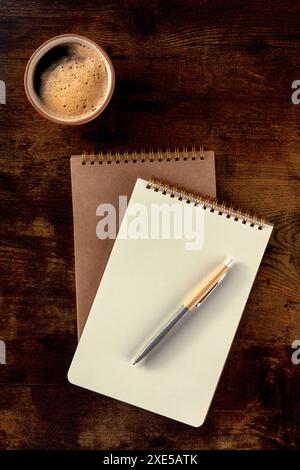 Notebook mockup with a pen and a cup of coffee, top shot Stock Photo