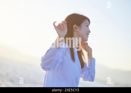 Young Japanese woman dancing while listening to music Stock Photo