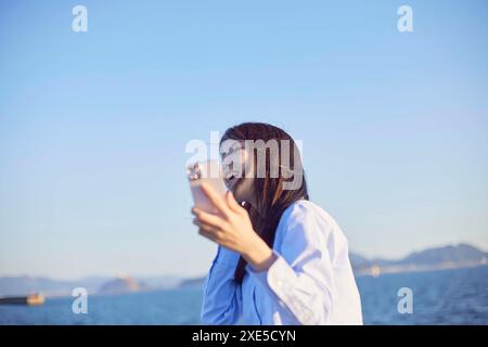Young Japanese woman dancing while listening to music Stock Photo