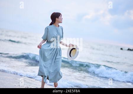 Young Japanese woman enjoying a vacation on the seaside Stock Photo