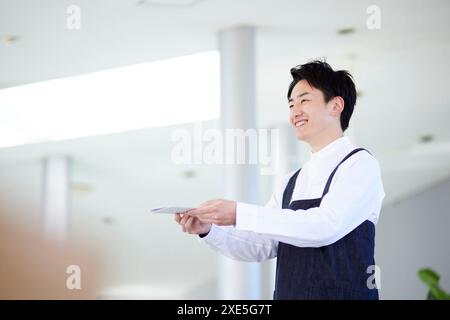 Young Japanese man working in café Stock Photo