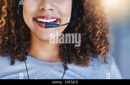 Woman, mouth and smile in call center with headset for customer service, crm and help or consulting. Agent, headphones and communication with clients Stock Photo