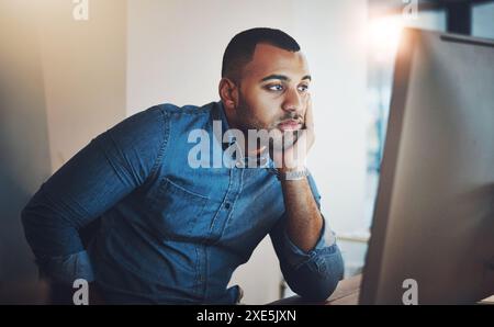 Businessman, bored and tired with computer in office, problem solving and solution with decision at night. Working late, web designer and monitor for Stock Photo