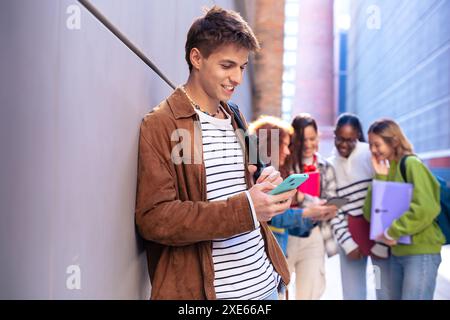 Young caucasian man browsing the internet using smartphone outdoors. Stock Photo