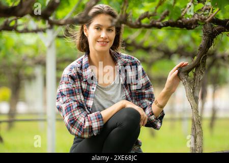 Portrait of a young woman in the vineyard with little grapes Stock Photo