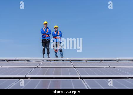 Portrait of two engineers working on a photovoltaic solar panels, Standing with their arms crossed Stock Photo