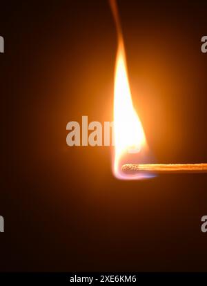red head matchstick ignite and lighting on in dark background Stock Photo