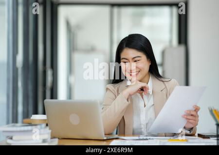 Businesswoman Analyzing Data on Laptop in Office. Stock Photo