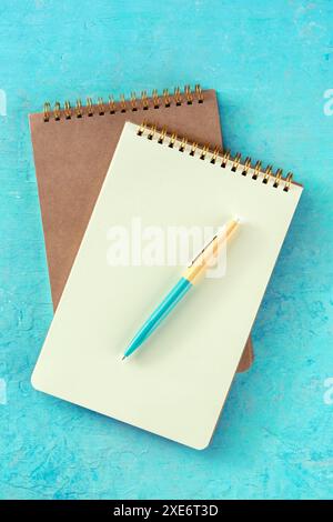 Notebook mockup with a pen, top shot on teal Stock Photo