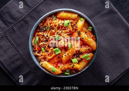 Rabokki, tteokbokki or topokki with ramen, Korean street food, spicy rice cakes in red pepper gochujang sauce, overhead flat lay shot Stock Photo
