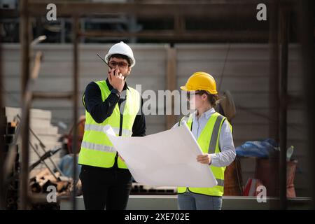 Engineer and architect working on the construction site, double-checking plans and process. Stock Photo