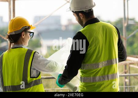 Engineer and architect working on the construction site, double-checking plans and process. Stock Photo