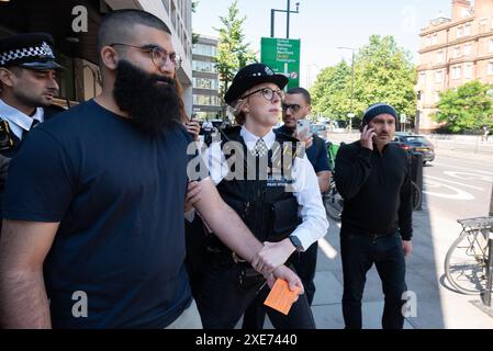 London, UK. 26 June, 2024. A man is arrested as supporters of Marieha Hussain, 37, protest outside Westminster Magistrates' Court where she faces a 'racially aggravated public order' charge for holding a placard mocking PM Rishi Sunak and ex-Home Secretary Suella Braverman during a pro-Palestine protest against Israel's war on Gaza. Credit: Ron Fassbender/Alamy Live News Stock Photo