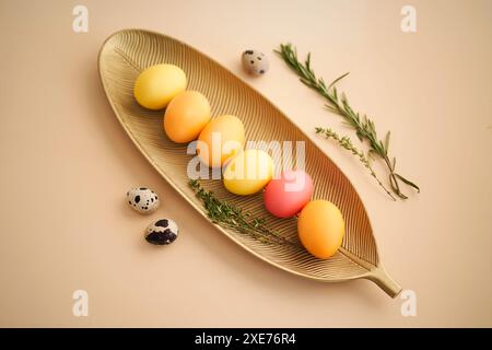 Easter eggs in pink, yellow and orange shades on a beige background. Stock Photo