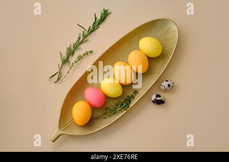 Easter eggs in pink, yellow and orange shades on a beige background. Stock Photo