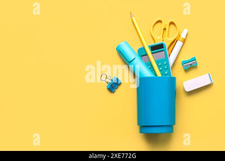 Top view of school blue jar with school supplies with space for text over yellow background. Back to school concept Stock Photo