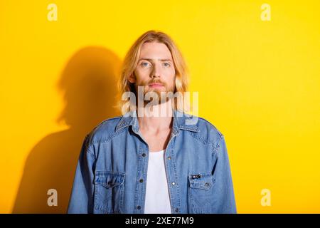 Photo portrait of attractive young man look camera dressed stylish denim clothes isolated on yellow color background Stock Photo