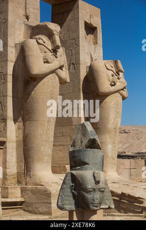 Granite Head of Ramesses II in front of Osiris Statues, Ramesseum, Memorial Temple of Pharaoh Ramesses II, 13th century BC, Ancient Thebes, Luxor Stock Photo