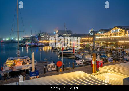 View of boats and restaurants in the Waterfront at dusk, Cape Town, Western Cape, South Africa, Africa Stock Photo