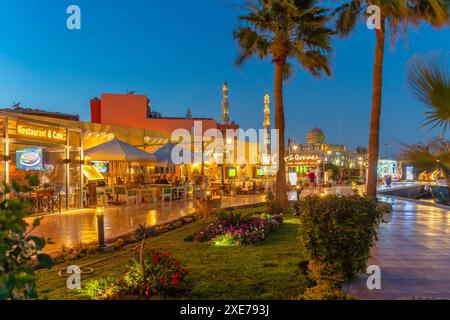 View of cafe and restaurant in Hurghada Marina and Al Mina Mosque in background at dusk, Hurghada, Red Sea Governorate, Egypt, North Africa, Africa Stock Photo