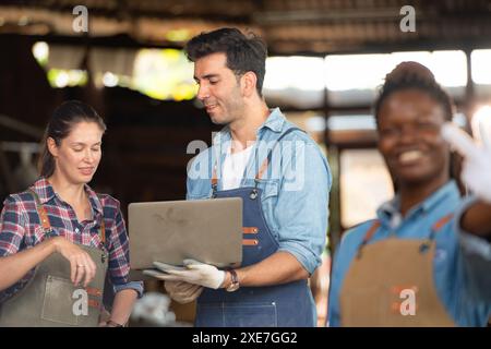 Portrait of carpenter female worker standing in front of colleague in workshop Stock Photo