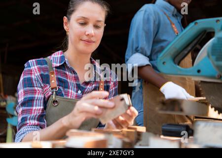 Portrait of female carpenter working in her workshop at countertop Stock Photo