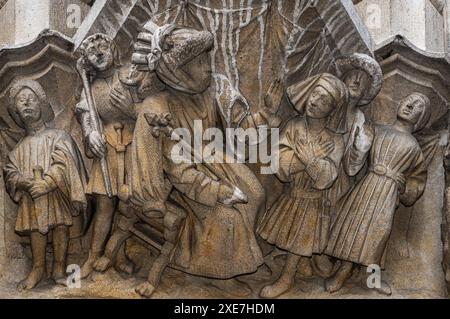 Biblical scene carved on corbel at base of niche on Flamboyant Gothic facade of the Stadhuis or Town Hall in the Grote Markt or Market Square at Leuven in Flemish Brabant, Flanders, Belgium.  The Stadhuis was built between 1439 and 1469 and the carved niche bases or corbels, featuring biblical characters, are part of the building’s original 1400s design. Stock Photo