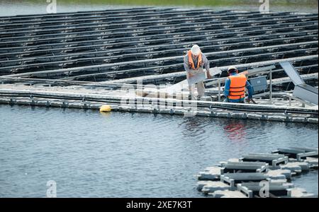 Both of technicians are currently evaluating and repairing the transmission terminals for electricity generated by solar energy Stock Photo