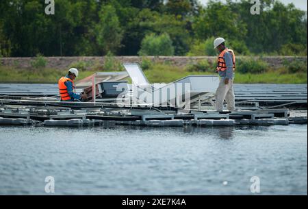 Both of technicians are currently evaluating and repairing the transmission terminals for electricity generated by solar energy Stock Photo