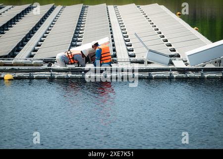 Both of technicians are currently evaluating and repairing the transmission terminals for electricity generated by solar energy Stock Photo