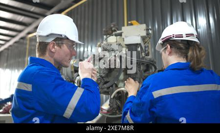 Both of engineers working together in a robotic arm factory, Robotic arm industry and engineering concept. Stock Photo