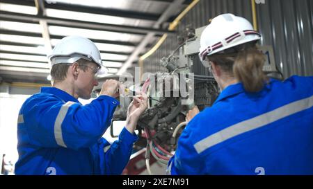 Both of engineers working together in a robotic arm factory, Robotic arm industry and engineering concept. Stock Photo