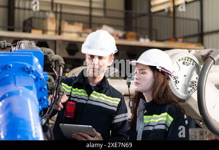 Both of engineers working together in a robotic arm factory, Robotic arm industry and engineering concept. Stock Photo