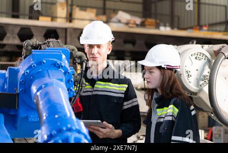 Both of engineers working together in a robotic arm factory, Robotic arm industry and engineering concept. Stock Photo