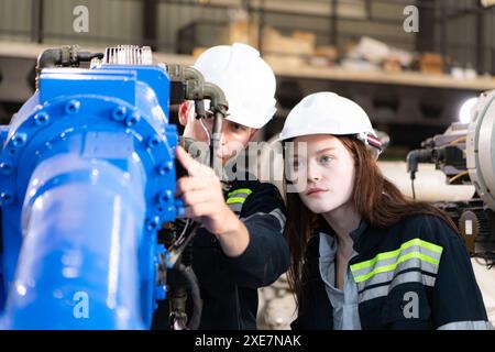 Both of engineers working together in a robotic arm factory, Robotic arm industry and engineering concept. Stock Photo