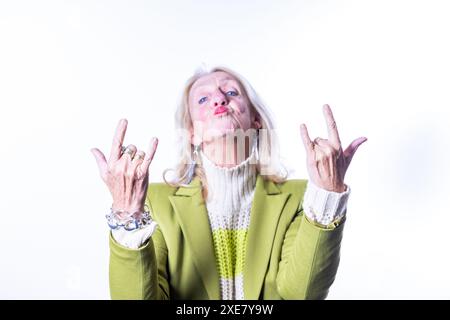 Playful Senior Woman Making Rock and Roll Hand Sign Stock Photo
