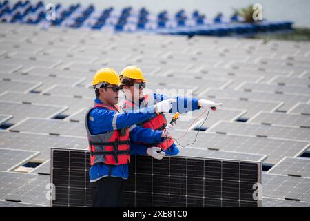 Photovoltaic engineers work on floating photovoltaics. Inspect and repair the solar panel equipment floating on the water. Stock Photo