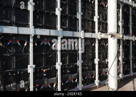 Close-up view of the backside of a large LED screen showing the intricate network of cables, connectors, and support structures. Stock Photo